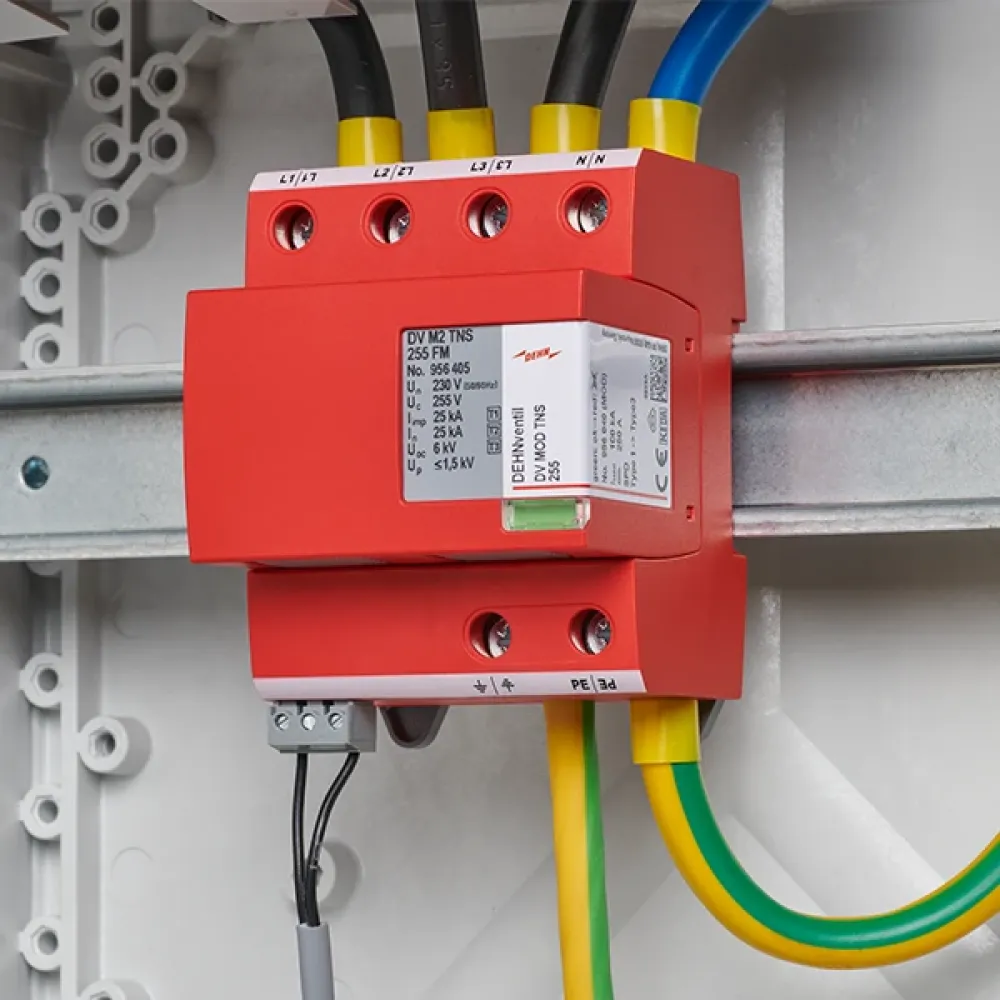 Red surge arrester, wired and mounted on a DIN rail in the switchgear cabinet.
