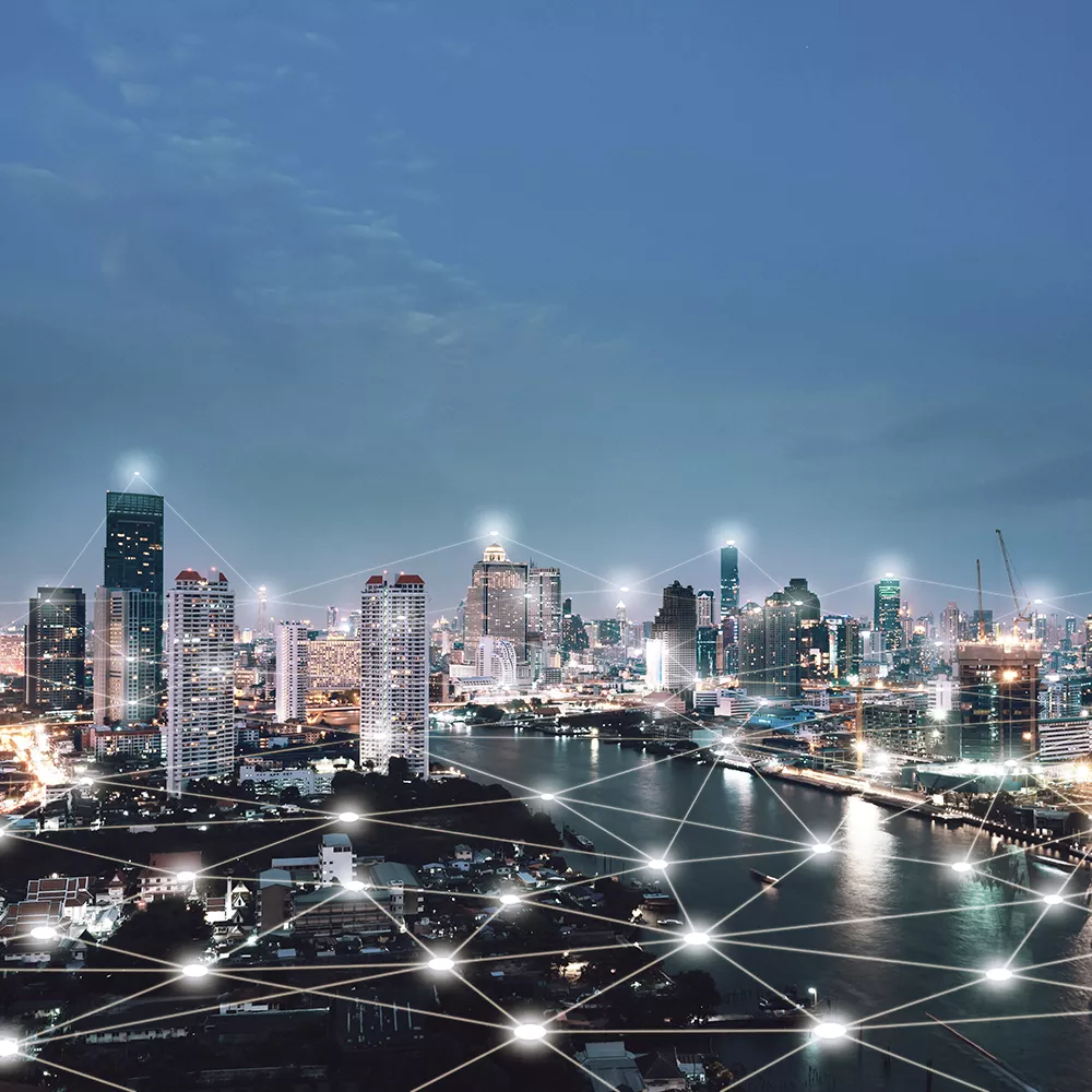 Bird's-eye view of a city with a river at night, in which many points are virtually connected by lines.